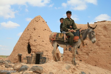 Photo - Jeune berger devant l'une des maisons traditionnelles de forme conique